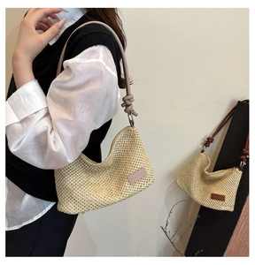 Détail du sac demi-lune tressé avec bandoulière nouée et écusson en cuir de marque