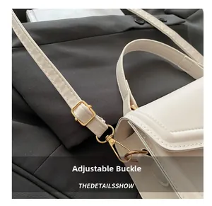 Close-up of adjustable white PU leather shoulder strap with gold hardware on handbag