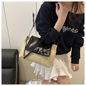Detail of woven crossbody bag with black leather flap and silver metal bow buckle closure