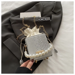 Close-up of snakeskin bucket bag with pearl handle, drawstring lining and gold feet