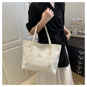 Détail du sac cabas blanc matelassé avec broderies papillons colorées et doubles bandoulières