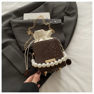 Close-up of brown snake pattern bucket bag with pearl handle and drawstring detail
