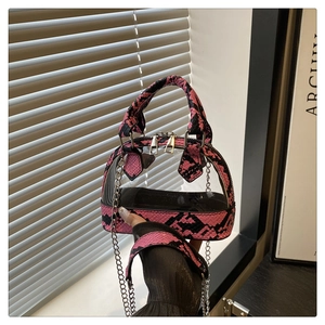 Detailaufnahme des rosa Schlangenmusters am transparenten Shopper mit silberner Kette