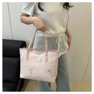 Détail d'un sac cabas rose matelassé orné de broderies papillon colorées en paillettes