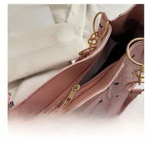 Detail of pink bow tote bag showing smooth gold zipper and wrinkled fabric texture