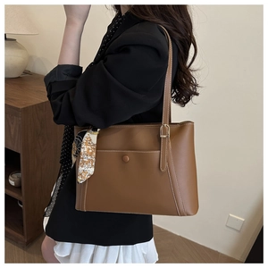 Detail of brown PU tote bag with white contrast stitching and decorative floral silk scarf