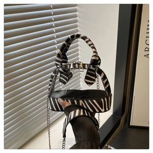 Detailansicht der Zebra-Print-Ränder und Doppel-Silberreißverschlüsse der PVC-Tasche
