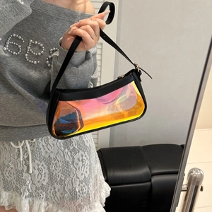 Holographic PVC baguette shoulder bag with black trim and adjustable strap on model