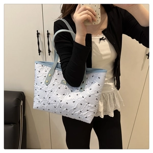 Gesteppte hellblaue Shopper Tasche mit schwarzen Schleifenmustern und schmalen Griffen