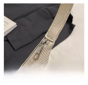 Close-up of silver metal zipper and woven texture on a minimalist tote bag