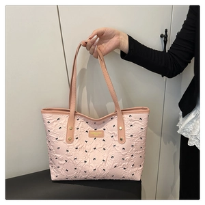Detailstruktur der rosa Tragetasche mit schwarzen Schleifenmustern und Markenlogo