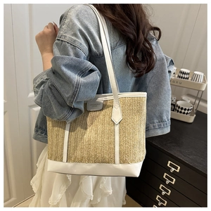 Détail des finitions en cuir contrasté et de la texture paille d'un grand sac cabas
