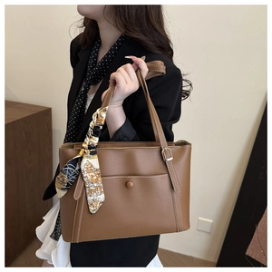 Detail of a brown PU tote bag featuring a decorative vintage floral scarf on the handle