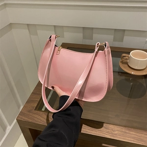 Borsa hobo minimalista rosa in ecopelle, tenuta a mano in un ambiente accogliente