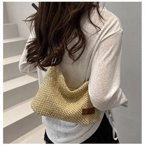 Détail du sac en paille fait main avec bandoulière en cuir et texture tissée rustique
