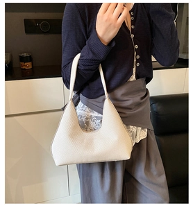 Detail of white woven texture and craftsmanship on a minimalist hobo shoulder bag