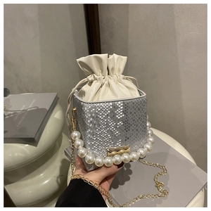Detail of silver snake-pattern mini bucket bag with large pearl handle and gold chain strap
