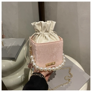 Detail of pink snake pattern bucket bag with pearl handle and drawstring closure