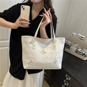 White tote bag with embossed letters and colorful gradient butterfly patterns
