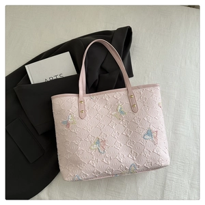 Détail du cabas rose avec broderie papillon pailletée et tissu texturé à carreaux 3D