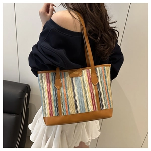Détail d'un sac cabas tissé multicolore avec lanières en cuir marron sur modèle