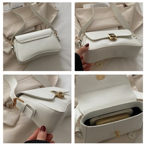 Detailed view of white half-moon saddle bag showing gold hardware and spacious interior