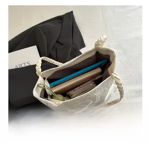 Detail view of large white textured tote bag showing spacious interior and woven handles