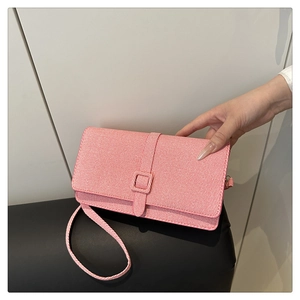 Détail du sac bandoulière rose en denim avec texture tissée et boucle carrée