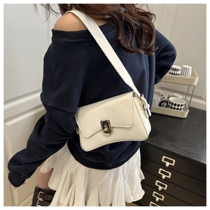 Close-up of white PU leather crossbody bag with distinctive black and gold hardware clasp