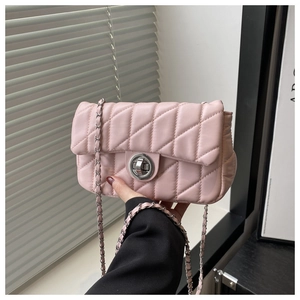 Détail du sac matelassé rose avec bandoulière chaîne argentée et fermoir rotatif en métal