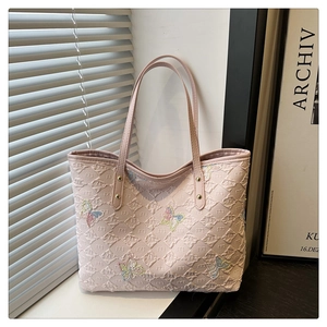 Détail du cabas rose avec texture matelassée et application papillon aux reflets irisés