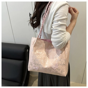 Detail of pink tote bag featuring 3D butterfly embroidery and lace texture on shoulder