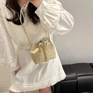 Woven straw bucket bag with floral embroidery and pearl drawstring for summer style