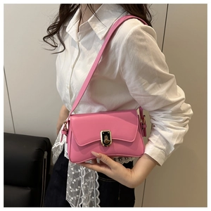 Side view of model wearing a pink PU leather crossbody bag with golden metal twist lock