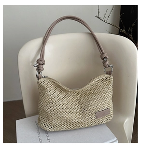 Détail du sac en paille tissée avec poignée en cuir marron nouée et anneaux métalliques