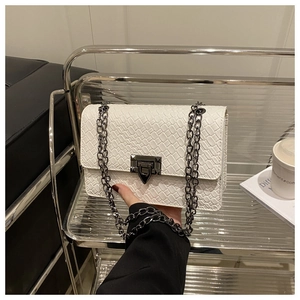 Détail du petit sac carré blanc tressé avec chaîne en métal et fermoir à pression