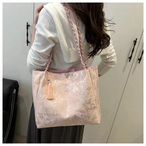Detail of light pink butterfly tote bag with floral lace fabric and braided straps