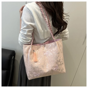 Close-up of pink lace jacquard shoulder bag with butterfly 3D appliques and tassel