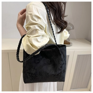 Detail of black jacquard tote bag with floral patterns and leather woven strap