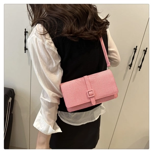 Détail arrière du sac baguette rose avec texture fine et boucle décorative argentée