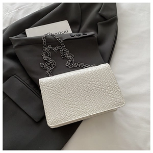 Détail du petit sac blanc tissé avec une bandoulière en chaîne gris anthracite