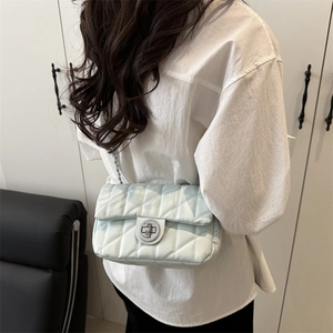 Sac à bandoulière matelassé vert menthe avec chaîne argentée porté par un mannequin