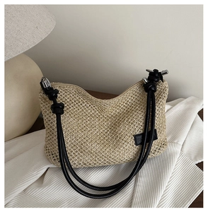Détail du sac tressé avec bandoulière à nœuds noirs et étiquette logo à la mode