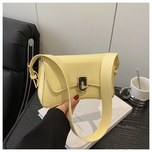 Detailed view of cream leather crossbody bag with elegant gold and black twist lock