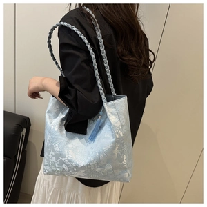 Detail of light blue butterfly jacquard tote bag with woven strap and tassel charm