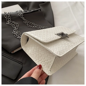 Détail du sac bandoulière blanc à texture tressée et grosse chaîne argentée