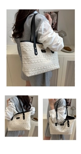 Detail of white woven tote bag with intricate lace-like texture and black leather straps