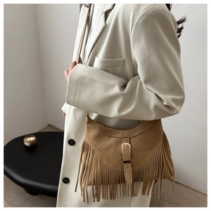 Close-up of brown faux suede crossbody bag featuring long bohemian tassels and metal buckle