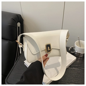 Detail of cream white crossbody bag featuring a gold square twist-lock and wide strap
