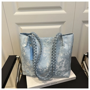 Detail of light blue butterfly embroidery and silk tassel on the satin tote bag